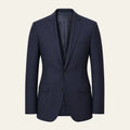 The Blazer in navy on a bone background, front view: single breasted, two buttons, notch lapel, welt chest pocket and flap hip pockets, tailored fit tapering at the waist