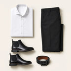 Flat lay of The Contrast Code on a bone background: folded white dress shirt, folded black trousers, black leather Chelsea boots and a coiled black leather belt