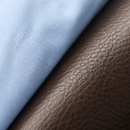 Macro close-up of light blue oxford cotton weave meeting the grained dark brown leather of the Chelsea boot