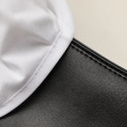 Macro close-up of white cotton shirt fabric meeting the grained black leather of the Chelsea boot