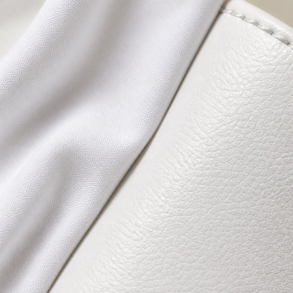 Macro close-up of white cotton shirt fabric meeting the smooth white leather of the sneaker, showing two different whites