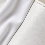 Macro close-up of white cotton shirt fabric meeting the smooth white leather of the sneaker, showing two different whites