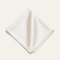 The Square in Ivory: folded silk pocket square with no contrast edge, on a bone background