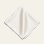 The Square in Ivory: folded silk pocket square with no contrast edge, on a bone background